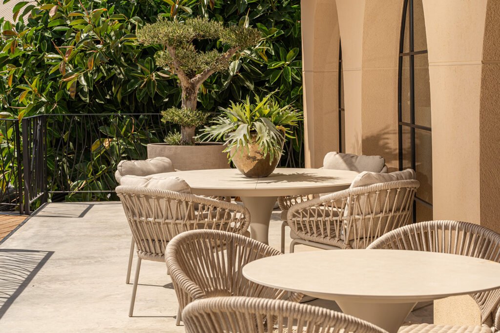 Round dining tables with rope chairs on a terrace